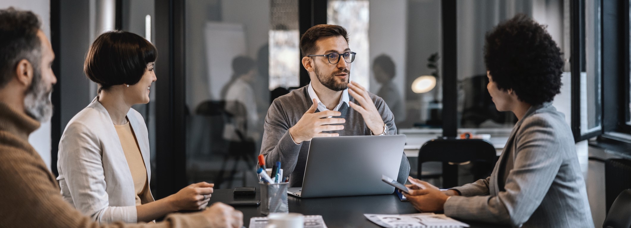 Kollegat istuvat palaverissa pöydän äärellä keskustelemassa