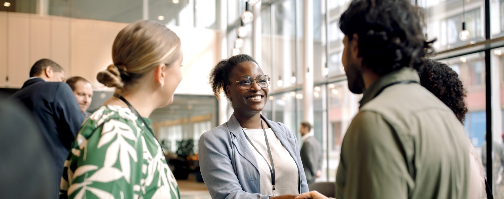 Hymyileviä ihmisiä kättelemässä