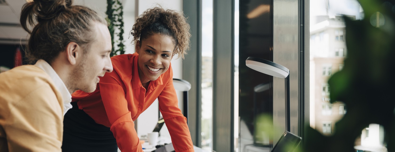 kaksi kollegaa keskustelevat tietokoneen vieressä