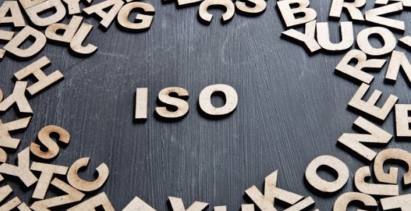 Sana "ISO" puisista kirjaimista tummalla pöydällä