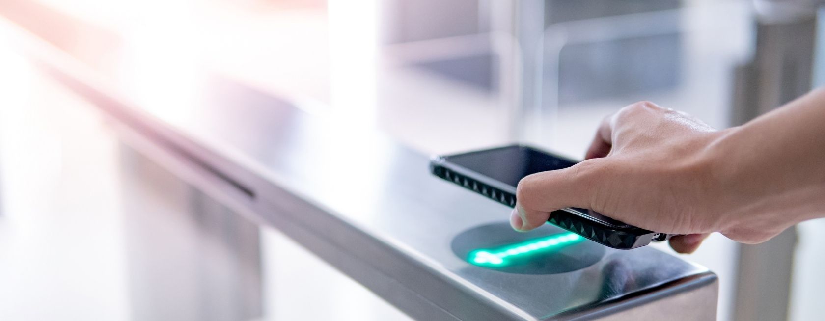 Male hand using smartphone to open automatic gate