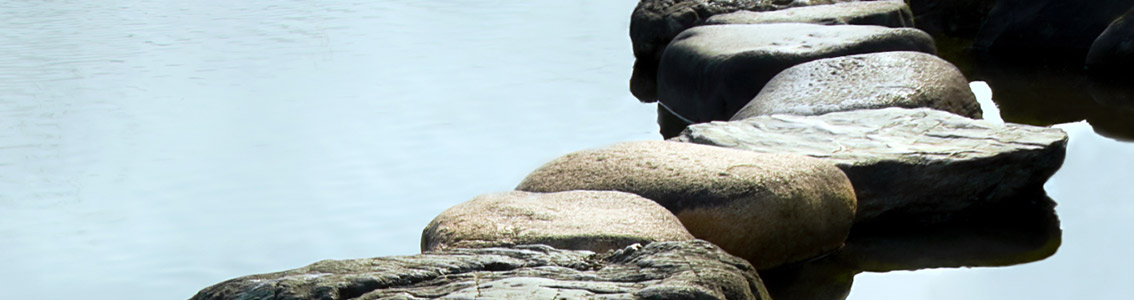 Polku pyöreistä kivistä veden ympäröimänä