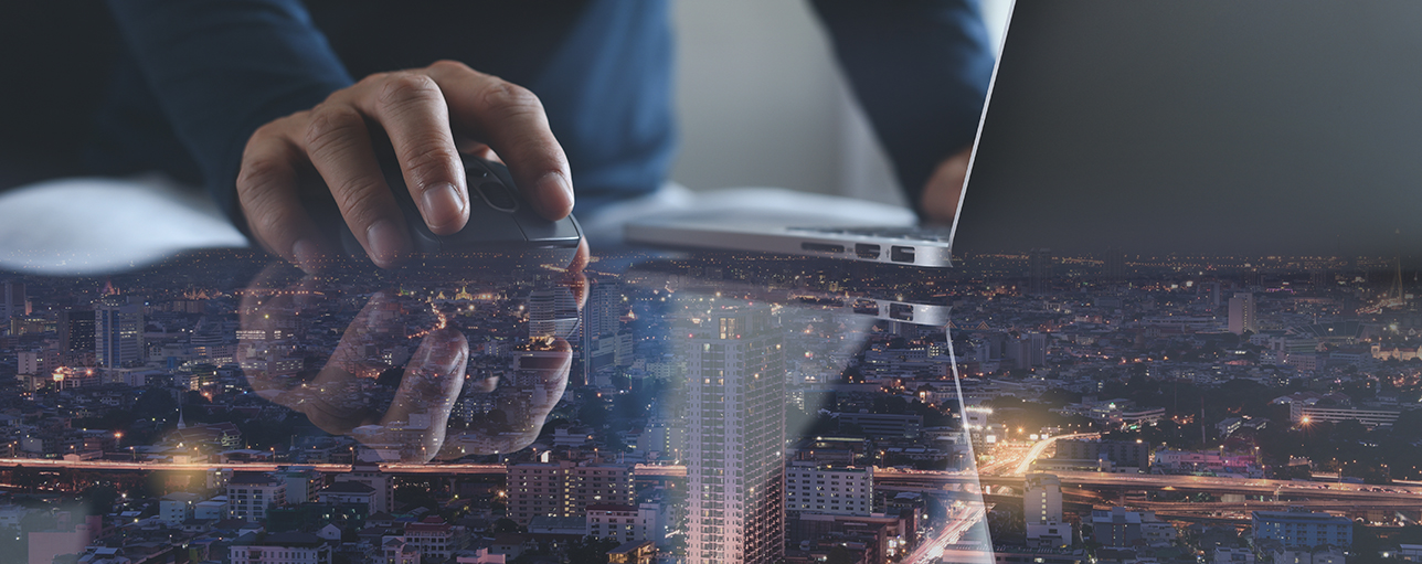 Miehen käsi hiiren päällä tietokoneen edessä