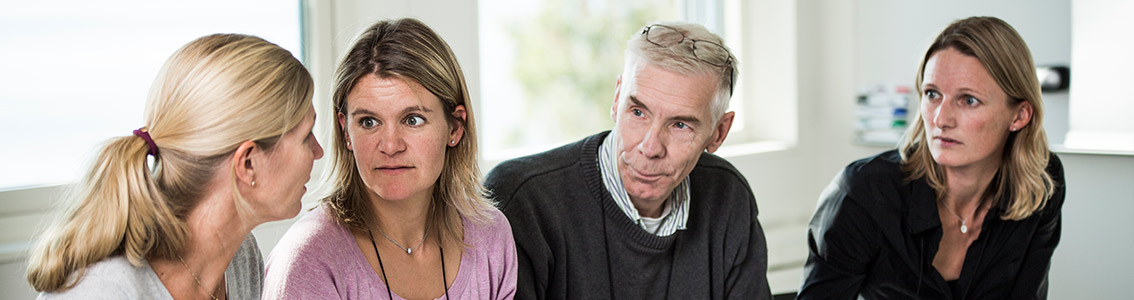 Kollegat keskustelemassa toimistossa pöydän äärellä